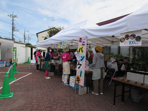 屋外でテントの屋根がある下に「ミニパンケーキ」ののぼりがでている写真