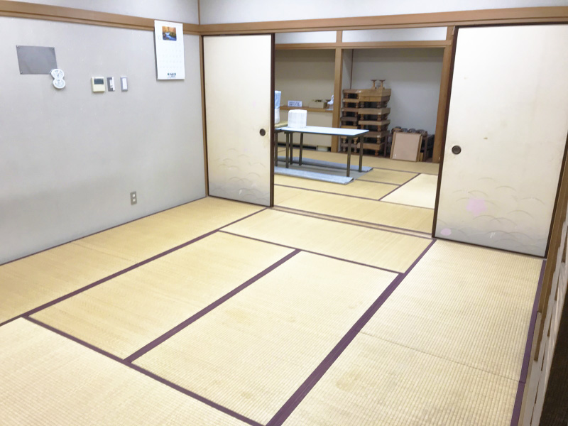 畳が敷かれふすまの奥にテーブルと囲碁台が置いてある部屋の写真