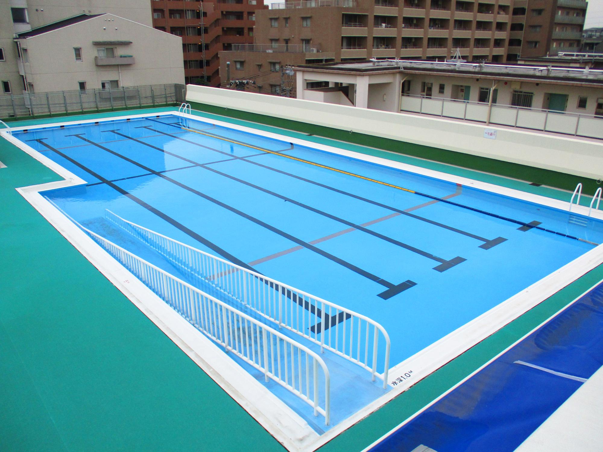 緑色のプールサイドの25メートルプールの写真