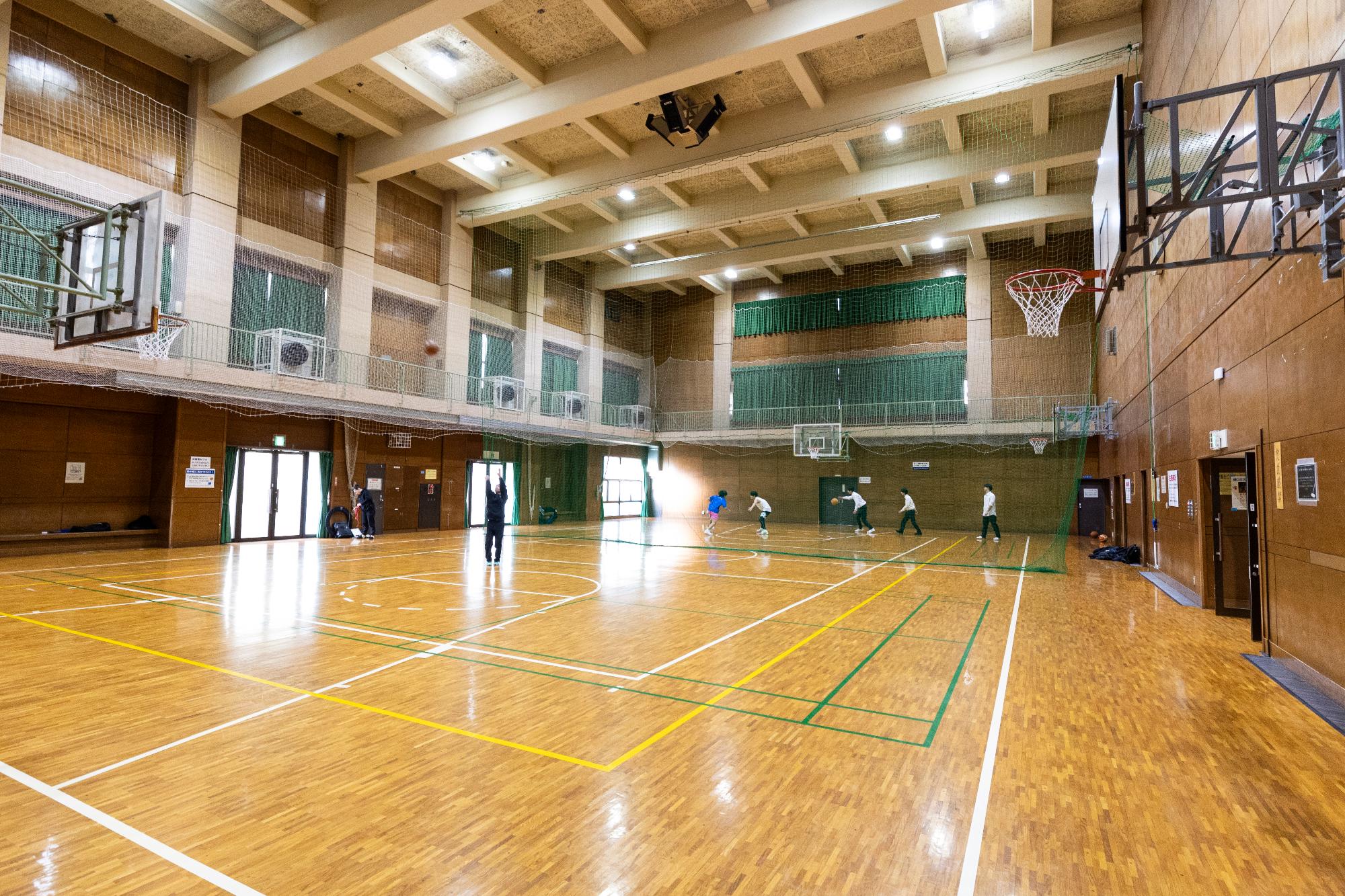 床にテープで区切りをしてある体育館の写真