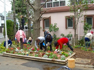 花壇の手入れをしている七名の人々の写真