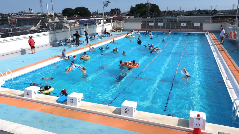 プールの写真。水色の水面。たくさんの市民が泳いでる
