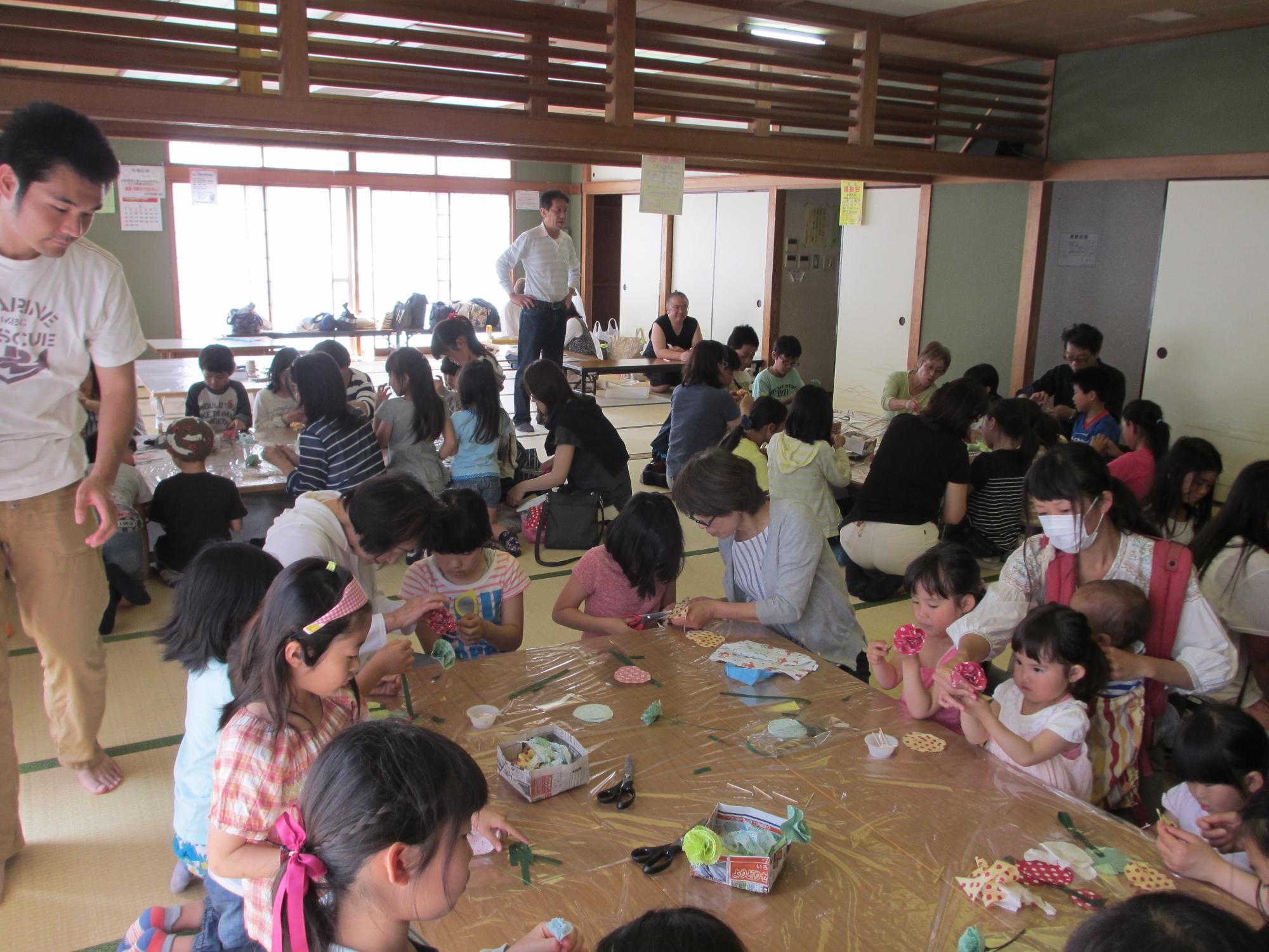 子どもが折り紙を織っている様子を上から写した写真