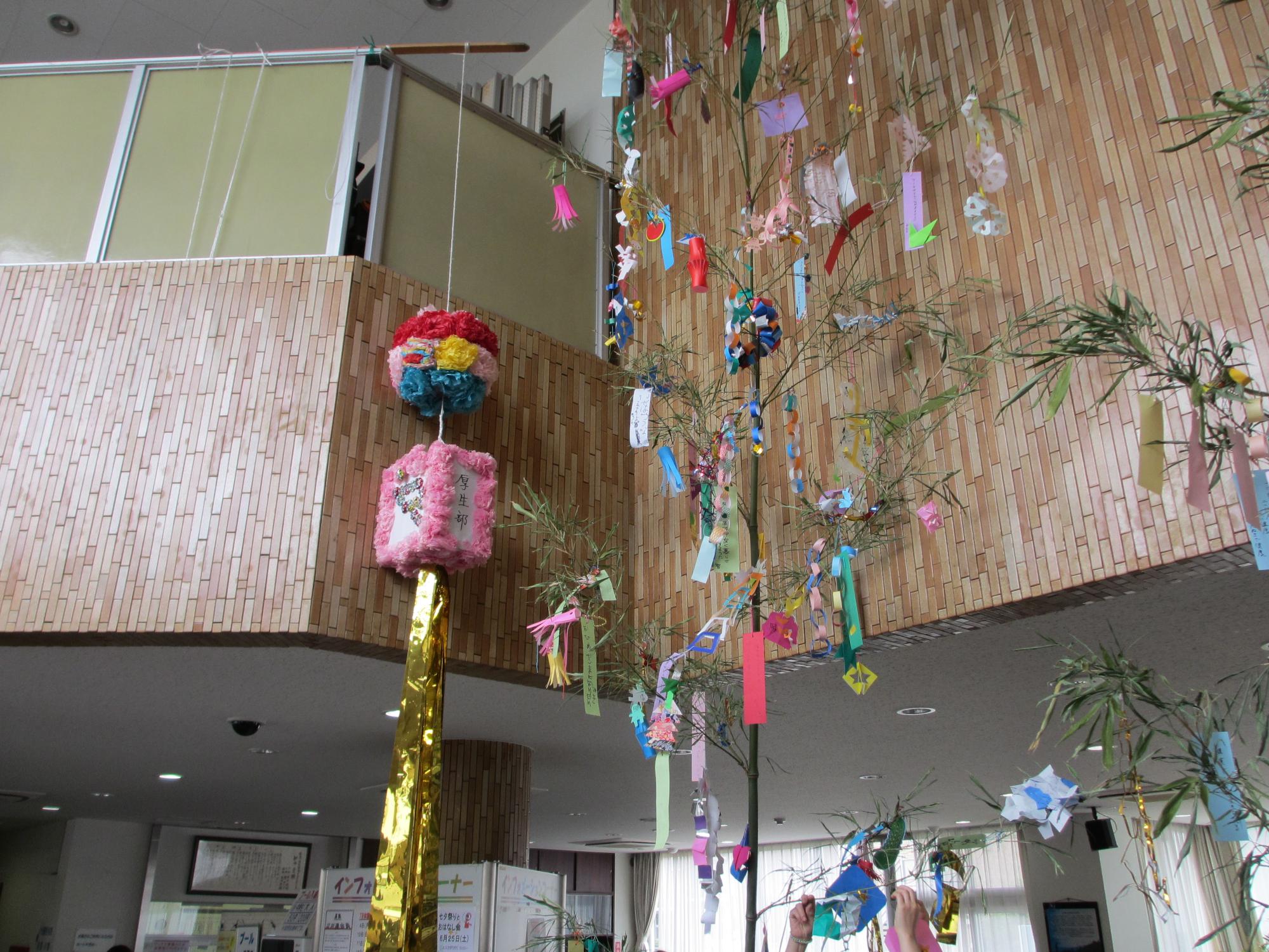 二階からぶら下げて飾られた、笹の葉と紙で出来たくす玉の写真