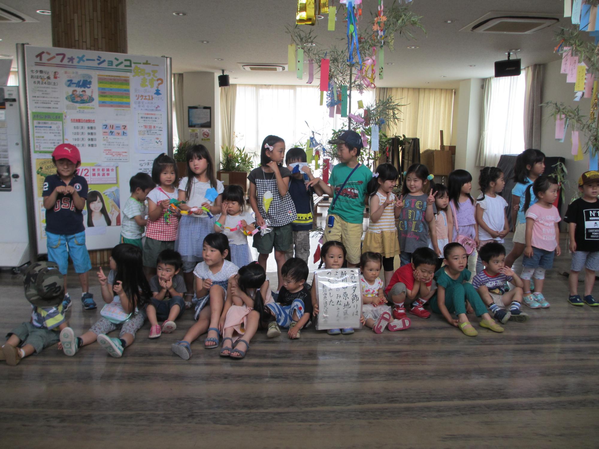 ロビーで集合した、笹の葉を背に集合して並んでいる大勢の子供たちの写真
