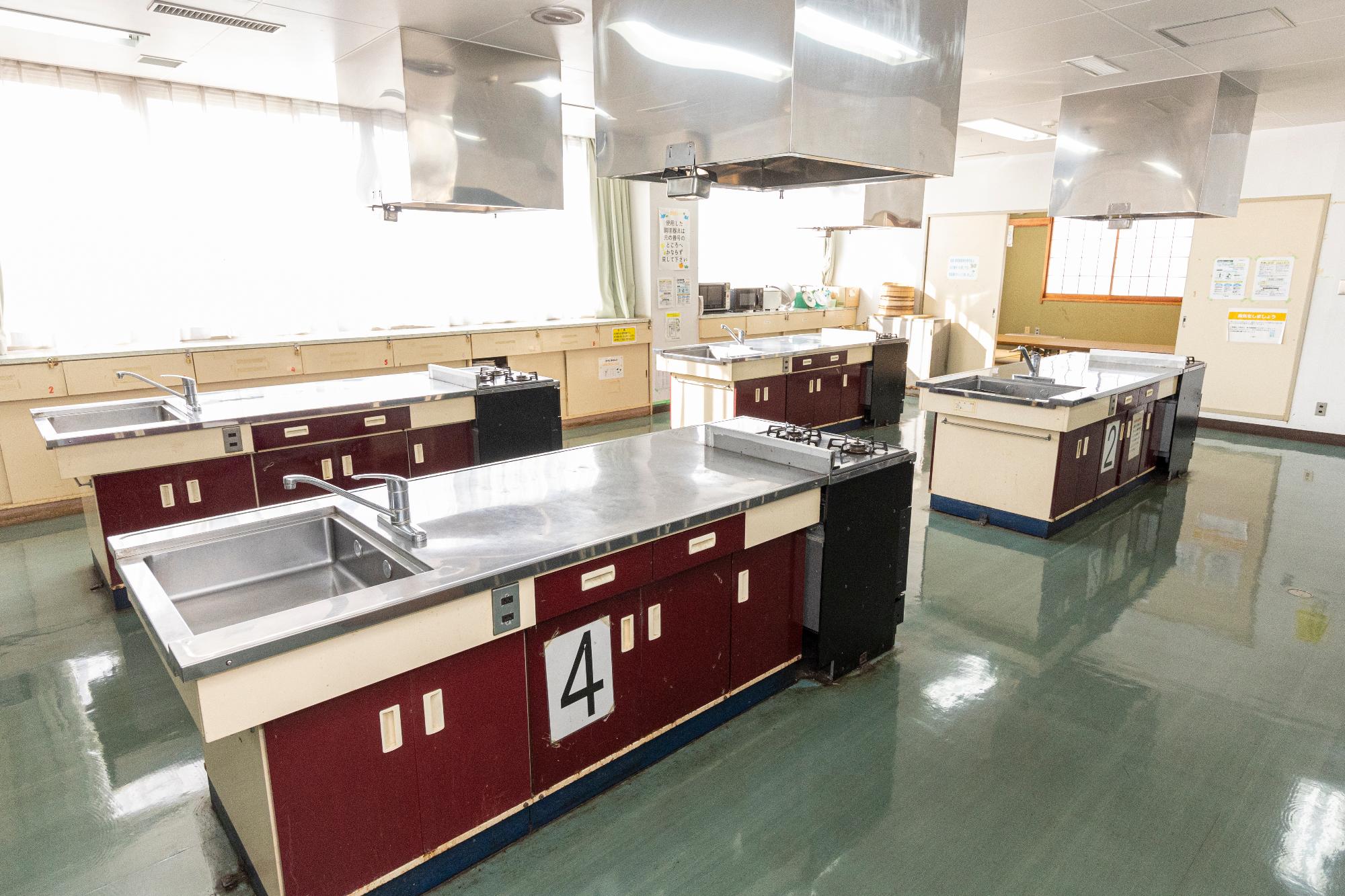 日光が入る部屋の中で、四台の流し台が写っている写真