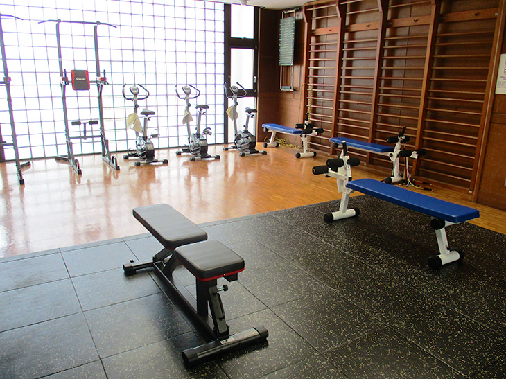 たくさんのトレーニング機器が置いてあるトレーニング室の写真