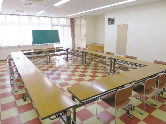 黒板がある赤と白のタイルの床の小会議室の写真