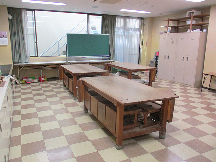 木のテーブルが並べられた工芸室の写真