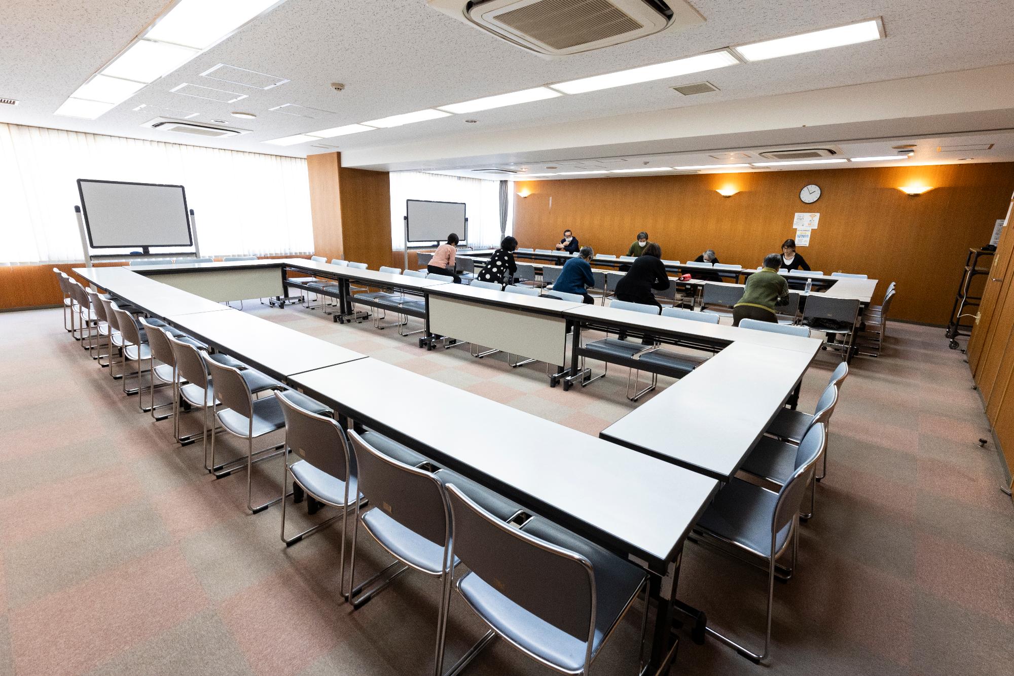 机と椅子の並べられた部屋の画像